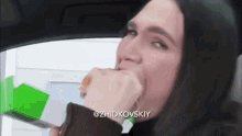 a woman is eating a sandwich in a car with the hashtag @zhidkovskyy