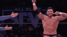 a shirtless wrestler is making a funny face with his fingers