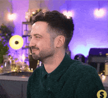 a man wearing a green shirt has a yellow s on his arm