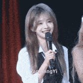 a woman holding a microphone with the name yang bing yi written on the bottom