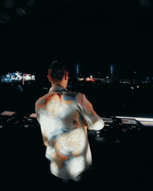 a man in a colorful shirt is playing a dj set
