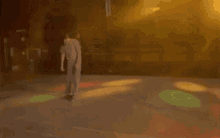 a blurry picture of a man standing on a dance floor in front of a stage