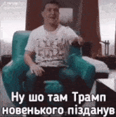 a man in a life full t-shirt is sitting in a chair in a living room