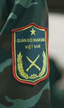 a patch that says quan doi nhan dan viet nam with two crossed swords on it