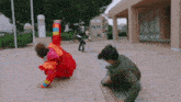 a man in a red jacket is doing a handstand on the sidewalk