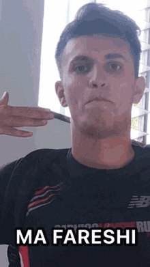 a man wearing a black shirt with the word ma fareshi on it