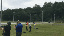 a group of people standing in a grassy field