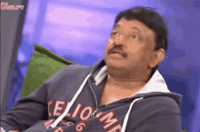 a man with a mustache is wearing a hoodie that says elio on it
