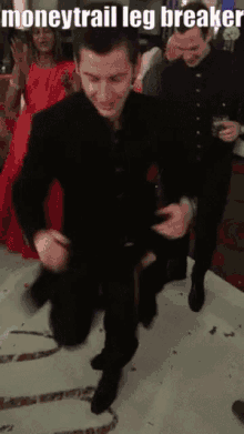 a man in a black suit is kneeling down on a dance floor with a caption that says moneytrail leg breaker