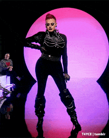a woman in a black jumpsuit is standing in front of a purple circle with t4yce tumblr written on the bottom