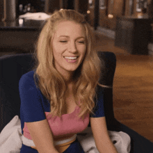 a woman sitting in a chair with her eyes closed smiling