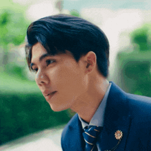 a man wearing a suit and tie with a flower pin on his lapel