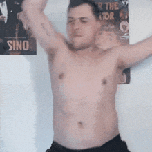 a shirtless man stands in front of a poster that says sino on it