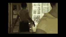 a man is standing in front of a mirror looking at himself .