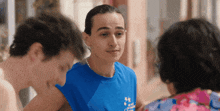 a man wearing a blue shirt that says ' a ' on it