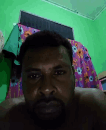 a man laying on a bed with a floral blanket on it
