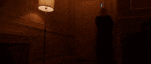 a woman in a black shirt is walking through a doorway with smoke coming out of it