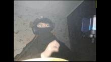a man wearing a mask and headphones is giving a fist bump