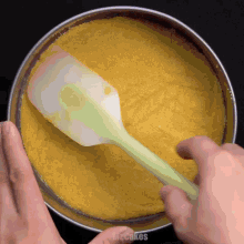 a person is using a spatula in a pan that says mrcakes on it