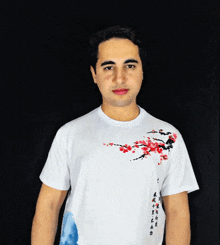 a man wearing a white t-shirt with a cherry blossom design on it