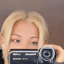 a woman is taking a selfie with a video camera that says ' ah.jun ' on it