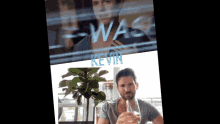 a man sitting in front of a window with kevin written on it