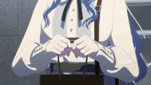 a woman with blue hair is holding a black bag in her hands