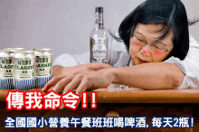 a woman is laying on a table with a bottle of classic beer in the background