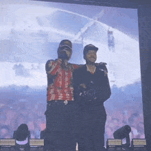two men are standing on a stage with one wearing a shirt that says lg on it