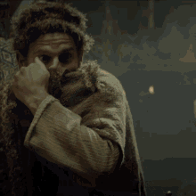 a man with a beard is wearing a fur coat and a fur hat