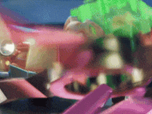 a blurred image of a pink and green object with a blue background