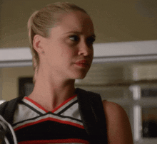 a cheerleader wearing a black white and red uniform looks to the side