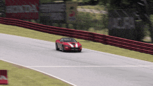 a red sports car is driving down a race track with a sign that says honda