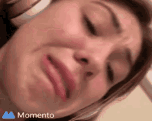 a close up of a woman making a funny face with the word momento in the corner .