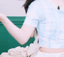 a woman in a blue shirt is pointing at another woman in a white skirt