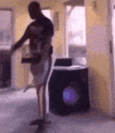 a man is standing in front of a washing machine in a room .