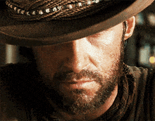 a man with a beard is wearing a hat