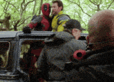 a man in a superhero costume is standing on top of a car