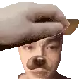 a hand is putting a dog mask on a person 's head .