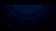 a blurred image of a red , pink , and blue light on a black background .