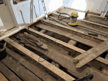 a yellow vacuum cleaner sits on a wooden floor next to a ladder