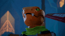 a toy lizard with a green scarf around its neck holds a sword