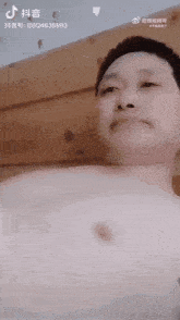 a man without a shirt is making a funny face while looking at the camera .