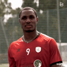 a man wearing a red jersey with the number 9 on the front