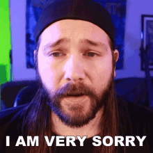 a man with long hair and a beard says i am very sorry with a sad look on his face