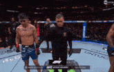 a fighter named mario bautista is standing next to a referee in a ufc match