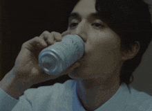 a man in a white shirt drinks from a can that says nitro