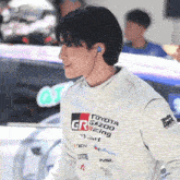 a man wears a white toyota gazoo racing shirt