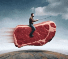 a man is riding on a large piece of meat