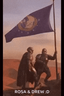 two men are holding a flag in the desert .